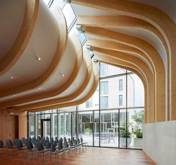 A photograph of the Cohen Quad at Exeter College, designed by Alison Brooks Architects, 展示了公司在适应性再利用和保护遗产彩票365官方网站方面的专业知识. 该图像突出了该彩票365官方网站对新元素和历史元素的敏感整合. Below the image, 文章指出，Alison Brooks彩票365官方网站事务所获得了Architizer A+奖的最佳中型公司奖, which is recognized in over 80 countries.